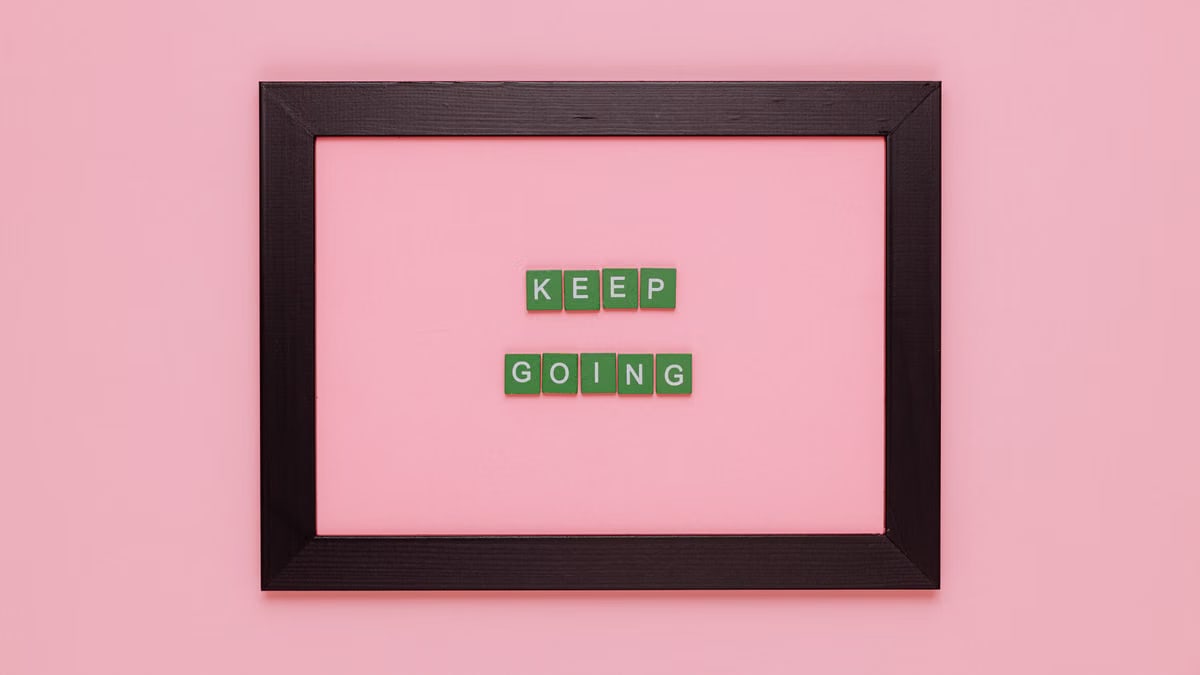 A framed motivational quote on a pink background for inspiration.